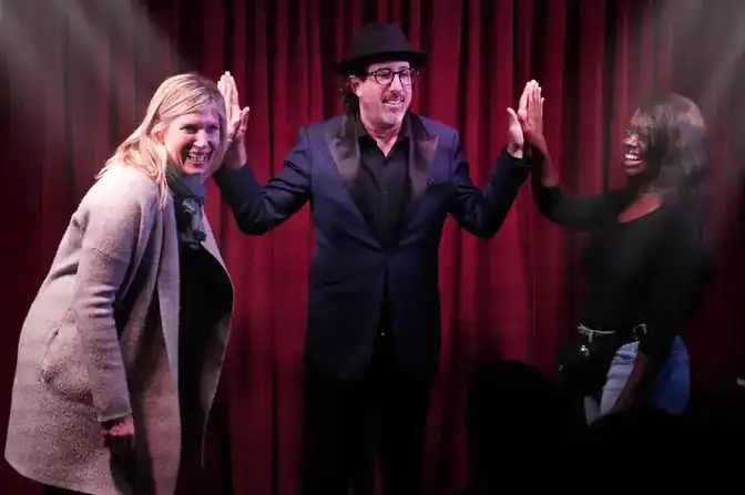 Jay Alexander high-fiving two volunteers on stage