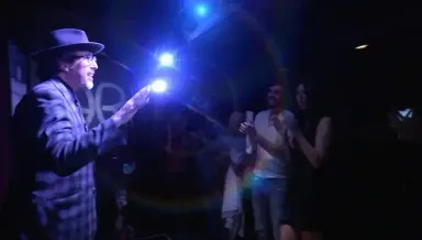 Jay Alexander receiving standing ovation with blue stage lights