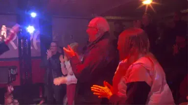 Standing ovation under red and blue stage lights