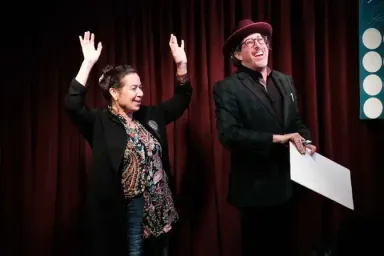 Audience volunteer with hands in the air during magic show